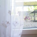 Vorhänge mit Blumen-Sujet.
