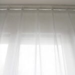 Weisse, transparente Vorhänge für Schienen.
